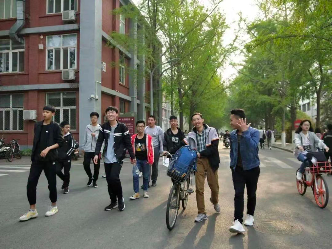 Chen Yishuai walking with students on the Kedou School campus
